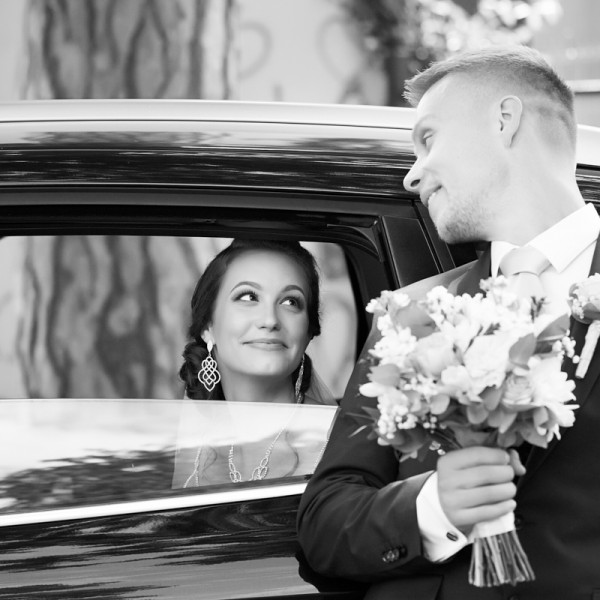 Svadobna momentka nevesty pozerajucej sa na zenicha z okna svadobneho auta
