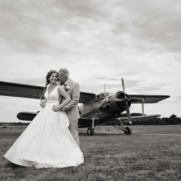 Ciernobiela fotka svadobneho paru pred vrtulovym lietadlom, letisko Dubova