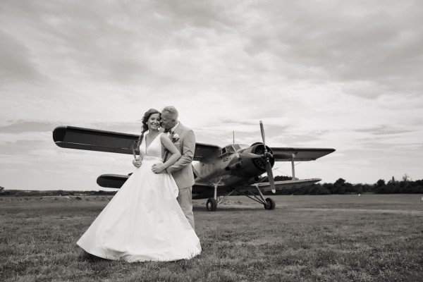 Ciernobiela fotka svadobneho paru pred vrtulovym lietadlom, letisko Dubova